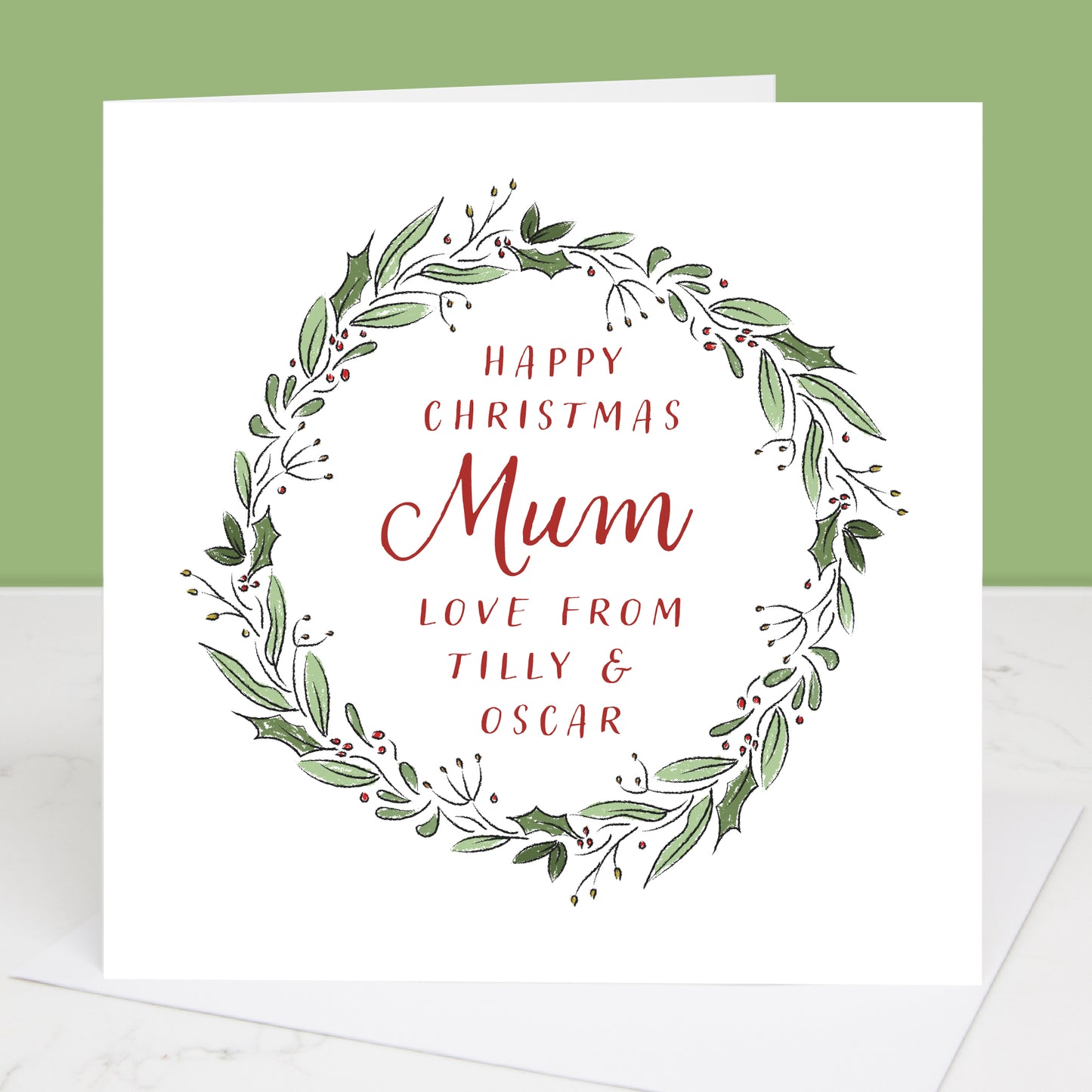 Christmas card with green wreath and red text on a white background