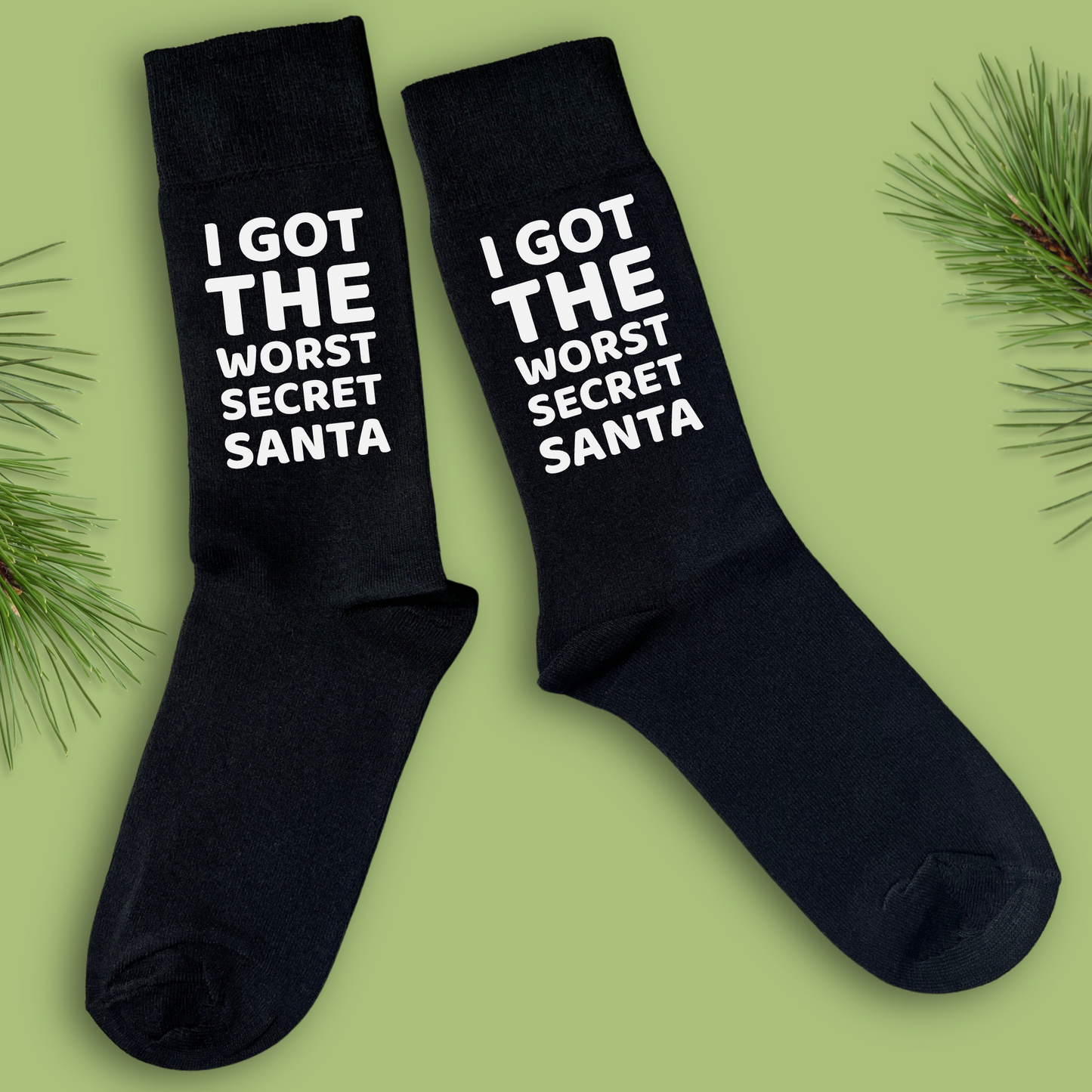 A pair of black Christmas socks with the text 'I GOT THE WORST SECRET SANTA' printed in white on each foot.
