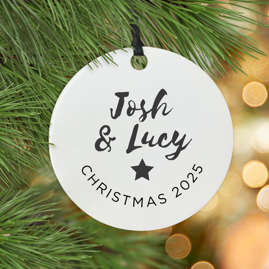 Personalised Christmas ornament with names hanging on a tree.