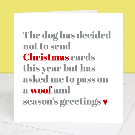 A Christmas card with a white background and text that reads 'The dog has decided not to send Christmas cards this year but has asked me to pass on a woof and season's greetings'