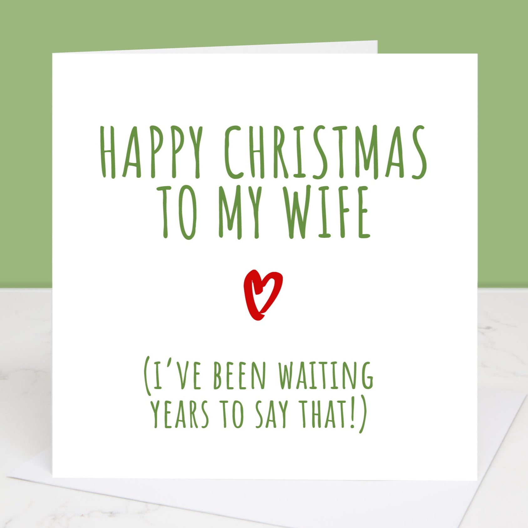 A Christmas card with a white envelope, featuring text that reads 'Happy Christmas to my Wife (I've been waiting years to say that!)' with a heart symbol.