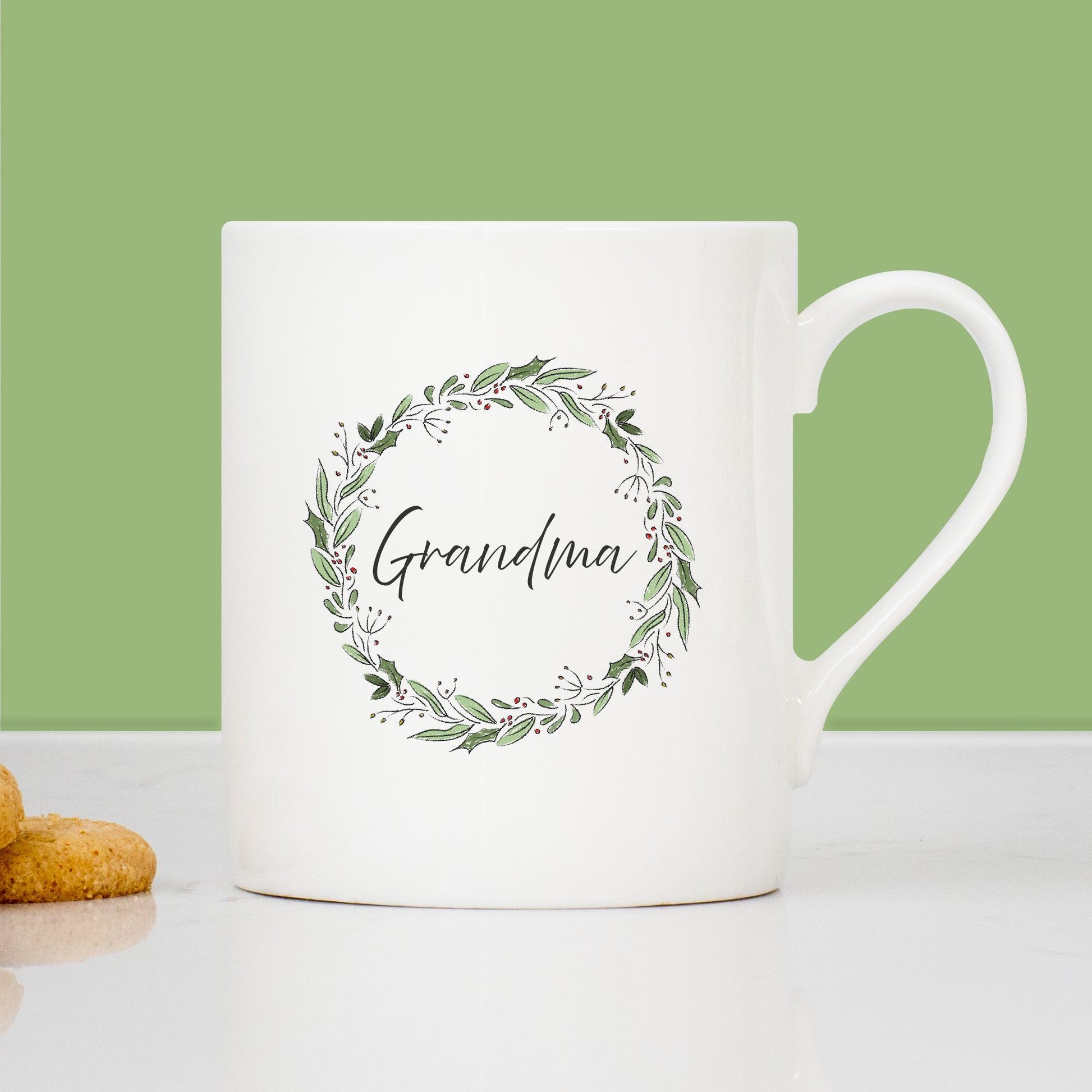White mug with 'Grandma' and floral wreath design on a green background