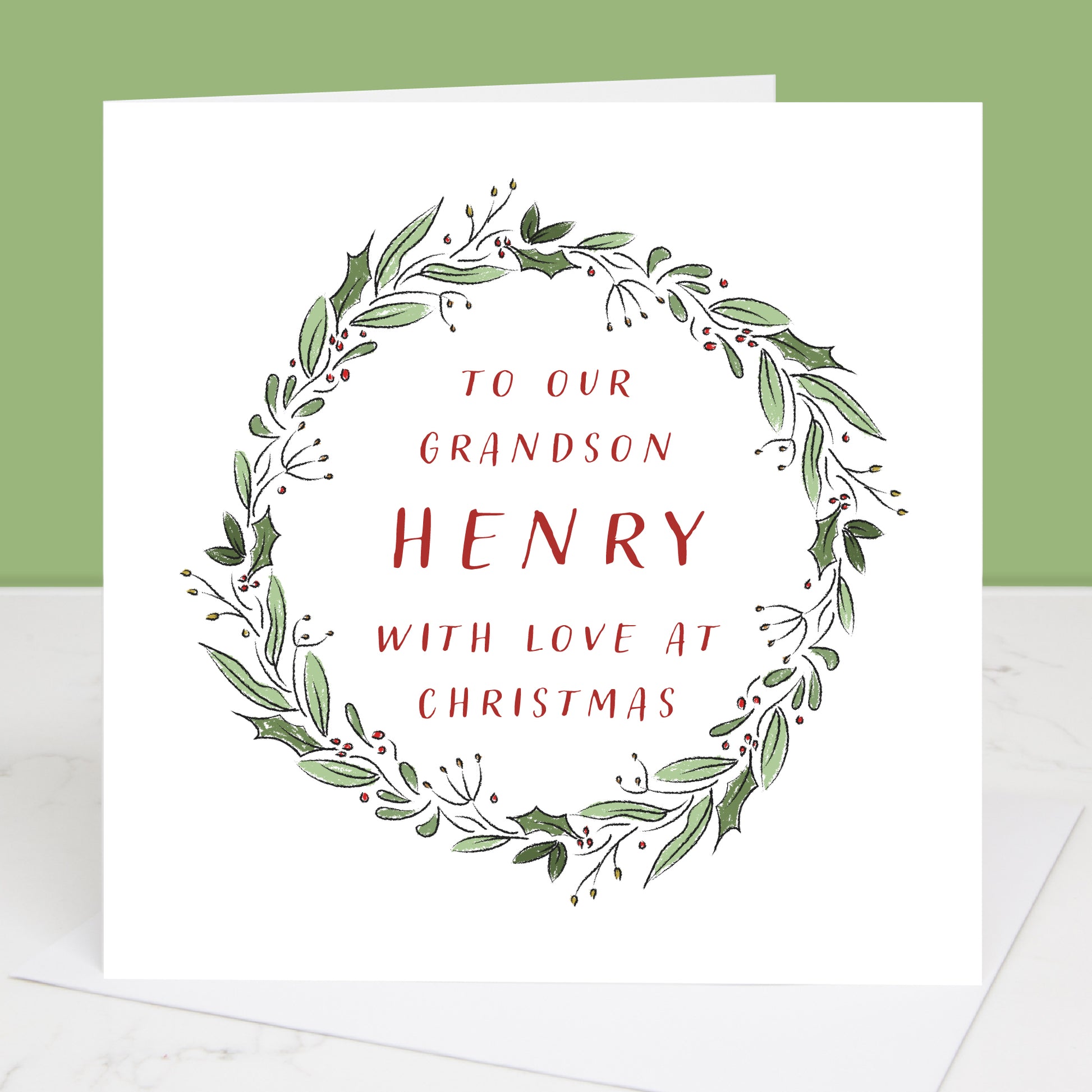 Grandson Christmas card with green leaf wreath and red text on a white background