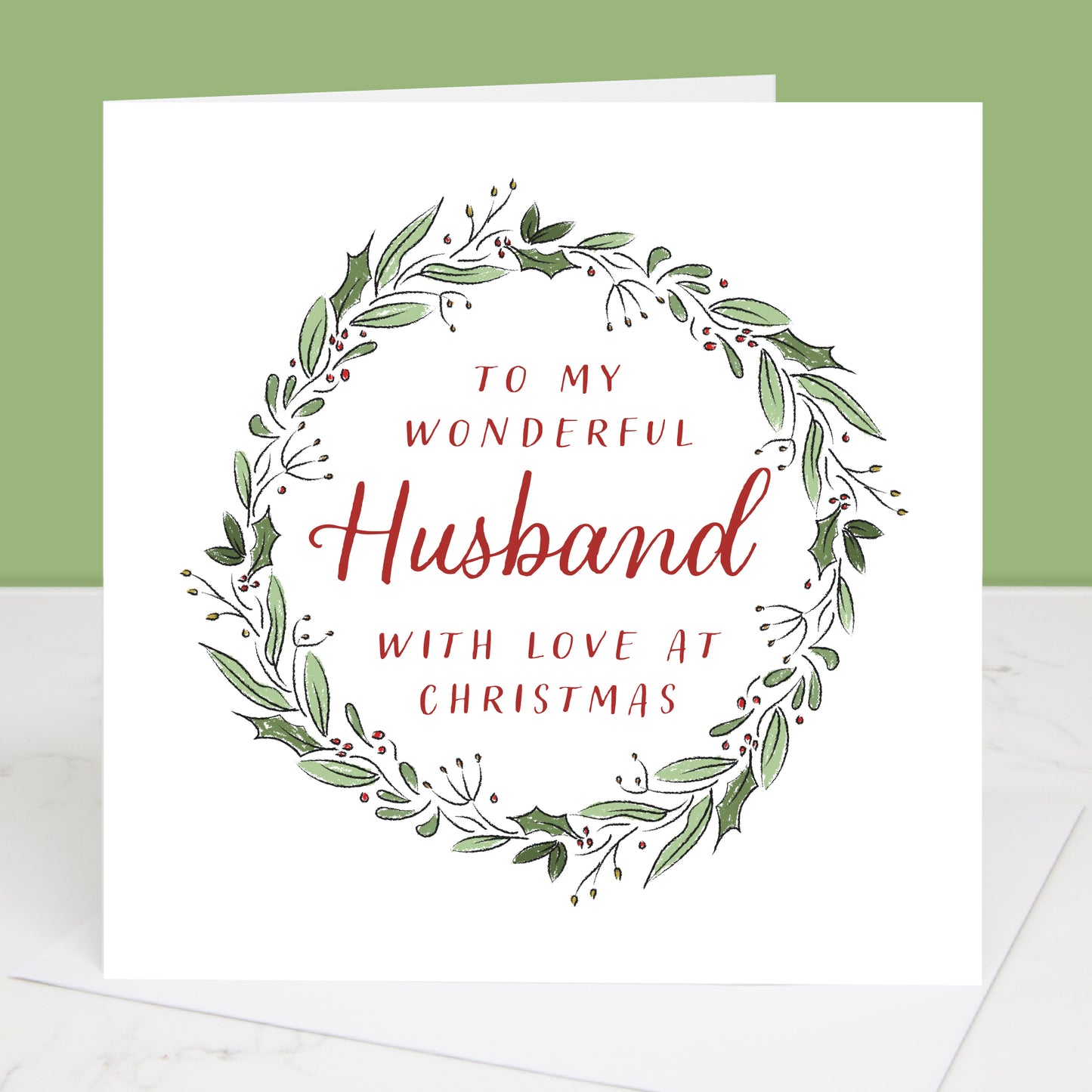Greeting card with festive wreath design and text 'To my wonderful husband with love at Christmas' on a white background.