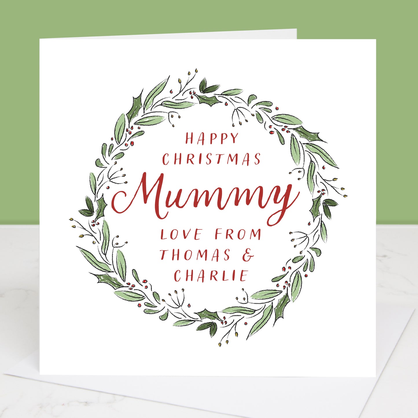 Christmas card with green wreath and red text on a white background