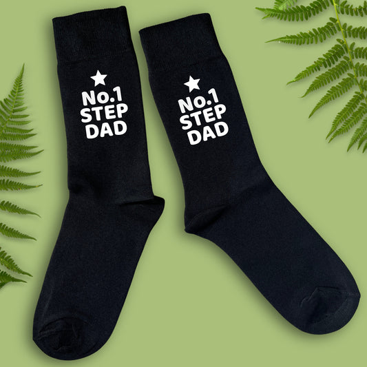 Black socks with 'No.1 Step Dad' text on a green background with fern leaves.